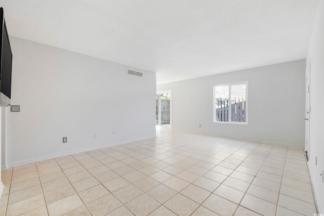 unfurnished room featuring light tile patterned floors, visible vents, and baseboards