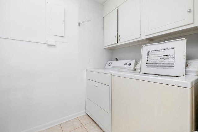 clothes washing area with light tile patterned floors, cabinet space, washing machine and dryer, electric panel, and baseboards