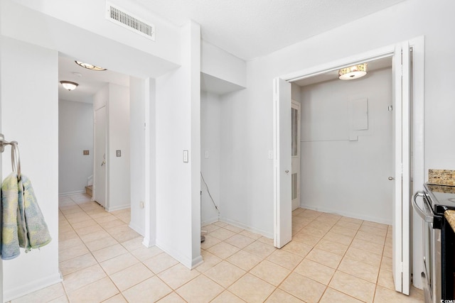 interior space featuring baseboards, visible vents, a textured ceiling, and light tile patterned flooring