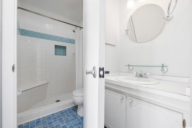 bathroom with toilet, tile patterned floors, tiled shower, and vanity