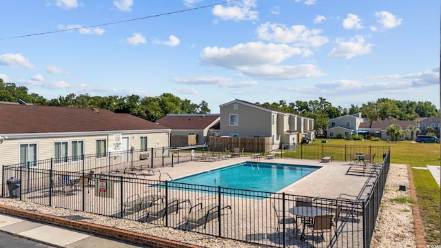 pool with a yard, a residential view, a patio, and fence