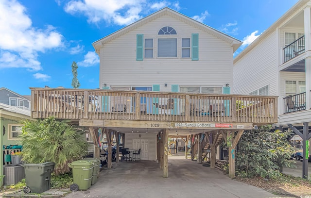 back of house featuring a wooden deck, a carport, and central AC unit