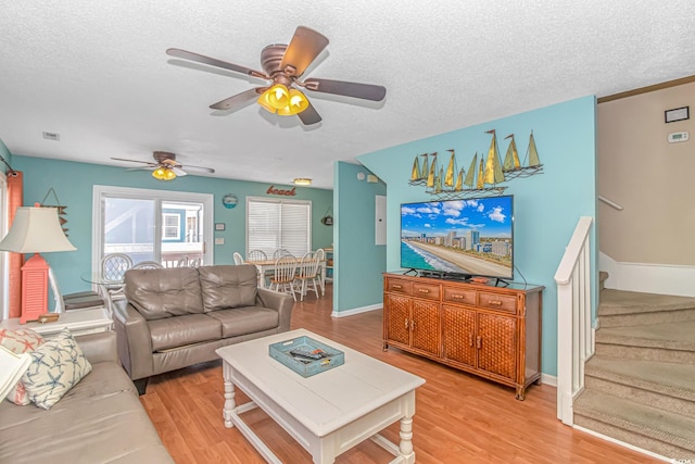 living room with hardwood / wood-style floors, a textured ceiling, and ceiling fan