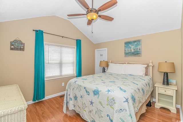 bedroom with ceiling fan, lofted ceiling, and light hardwood / wood-style flooring