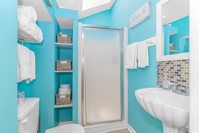 bathroom featuring an enclosed shower, sink, decorative backsplash, and toilet