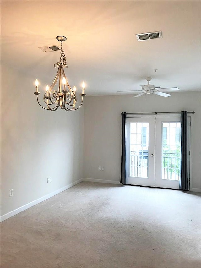 unfurnished room featuring carpet flooring, a notable chandelier, and french doors