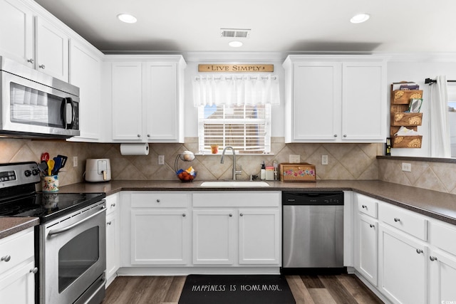 kitchen featuring white cabinets, sink, stainless steel appliances, and tasteful backsplash