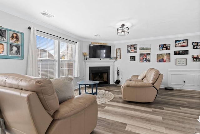 living room featuring wood-type flooring and ornamental molding