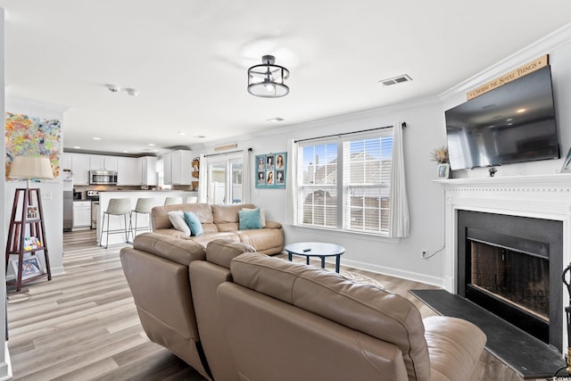 living room featuring light hardwood / wood-style floors and ornamental molding