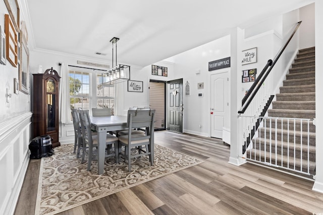 dining room featuring hardwood / wood-style floors and crown molding