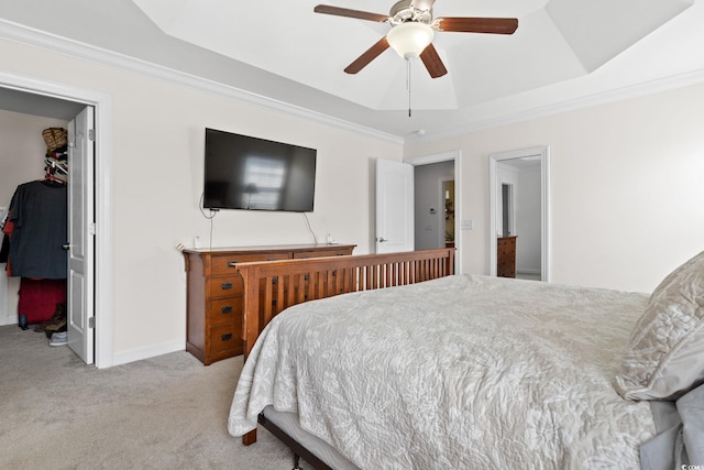 bedroom with light carpet, a raised ceiling, crown molding, ceiling fan, and a closet