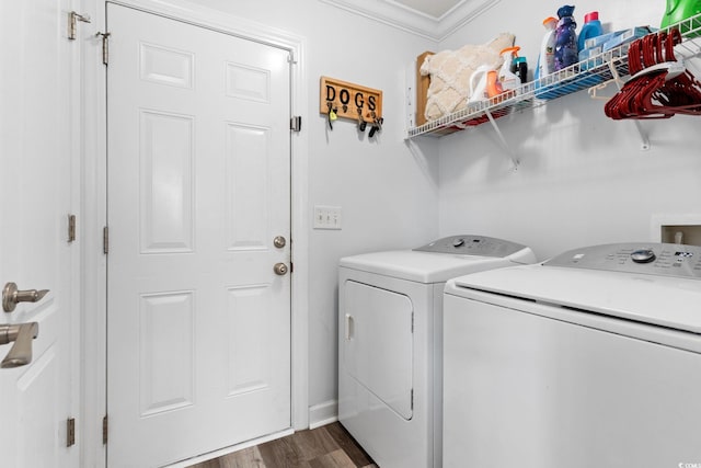 laundry area featuring dark wood-type flooring, crown molding, and washing machine and clothes dryer