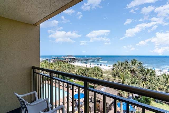 balcony featuring a view of the beach and a water view