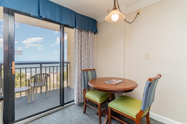 dining area with a water view, a wealth of natural light, and crown molding