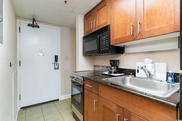 kitchen with sink, light tile patterned flooring, a drop ceiling, and stainless steel range with electric stovetop