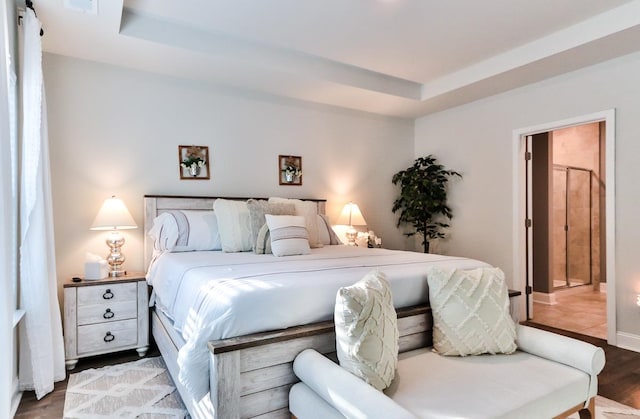 bedroom featuring dark hardwood / wood-style floors and a raised ceiling