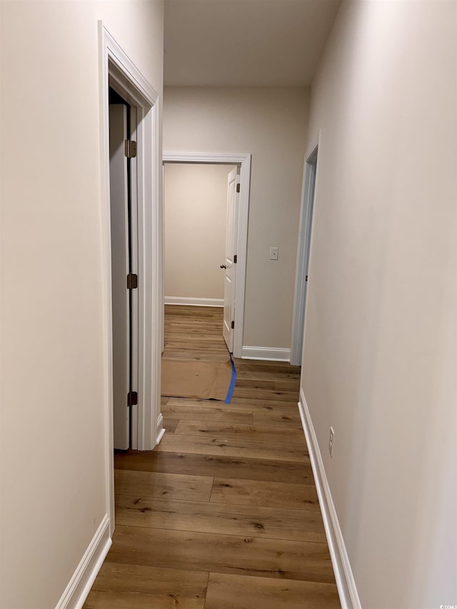 hallway with hardwood / wood-style floors