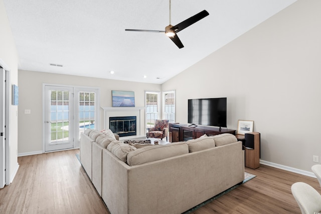 living room with ceiling fan, high vaulted ceiling, and light hardwood / wood-style floors