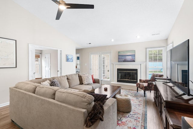 living room with ceiling fan, wood-type flooring, and lofted ceiling