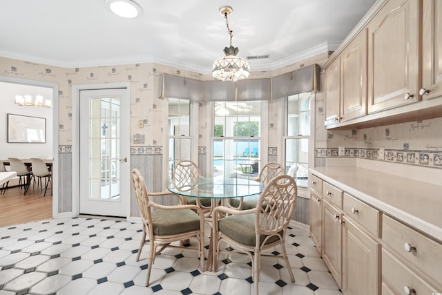 interior space featuring a wealth of natural light, a notable chandelier, and ornamental molding