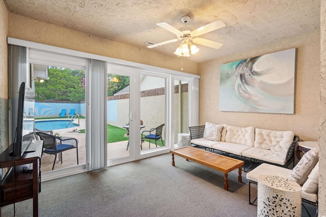 living room featuring a textured ceiling and ceiling fan