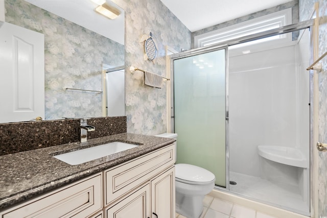 bathroom featuring a stall shower, vanity, toilet, and wallpapered walls