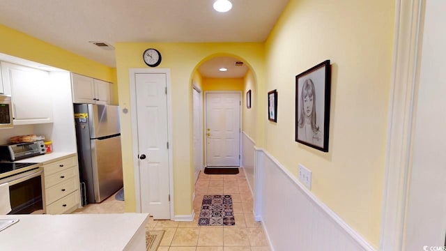 kitchen with white cabinetry, light tile patterned floors, and appliances with stainless steel finishes