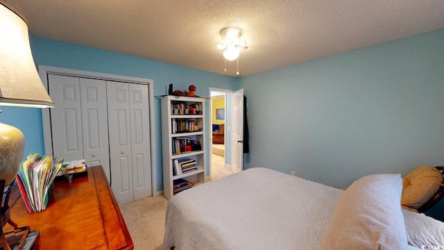 bedroom featuring light colored carpet, a textured ceiling, and a closet