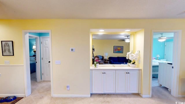 interior space featuring light colored carpet and ceiling fan