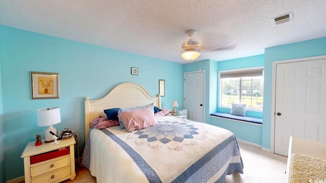 carpeted bedroom with a textured ceiling and ceiling fan