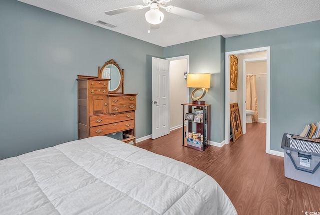 bedroom with ceiling fan, dark hardwood / wood-style floors, and a textured ceiling