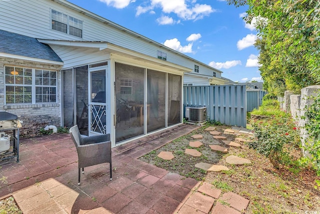 view of patio featuring area for grilling, central AC unit, and a sunroom