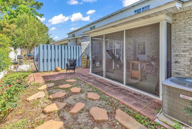 view of patio / terrace with central AC and a sunroom