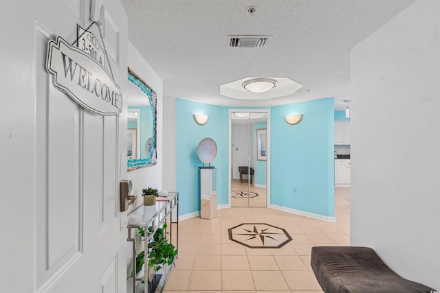 hallway with light tile patterned floors and a textured ceiling