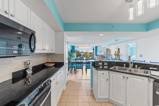 kitchen featuring pendant lighting, white cabinets, appliances with stainless steel finishes, light tile patterned floors, and sink