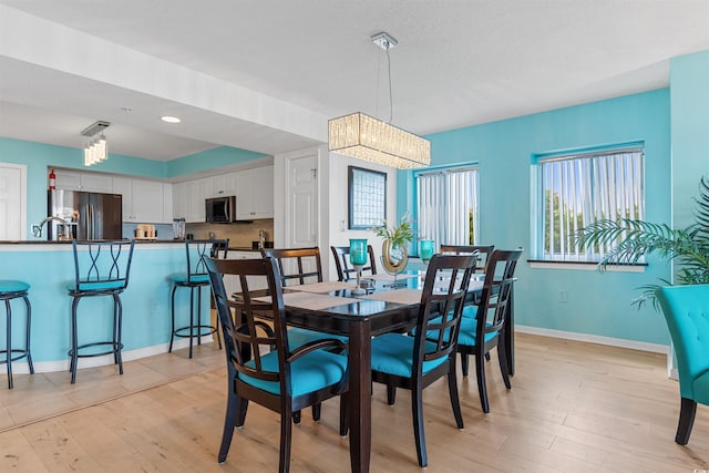 dining area featuring an inviting chandelier and light hardwood / wood-style flooring