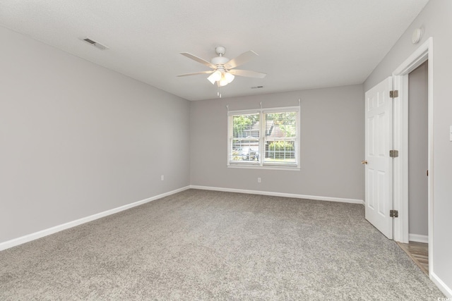 carpeted spare room with ceiling fan and a textured ceiling