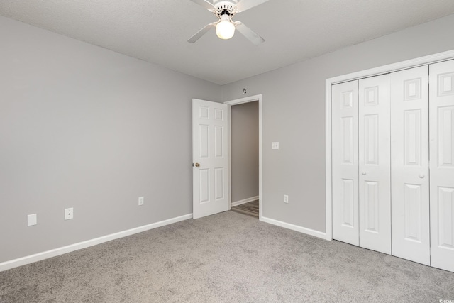 unfurnished bedroom with light colored carpet, a closet, and ceiling fan