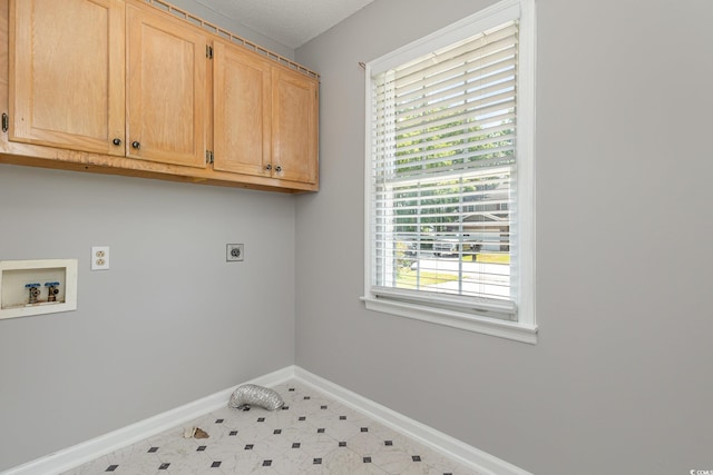 clothes washing area with cabinets, electric dryer hookup, and washer hookup