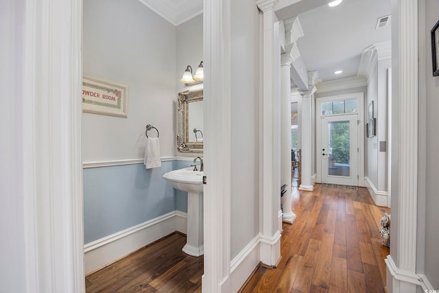 bathroom featuring hardwood / wood-style floors, ornate columns, and crown molding