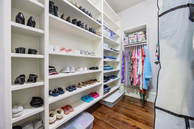 walk in closet with dark hardwood / wood-style flooring