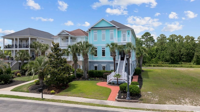 view of front of house with a balcony and a front yard