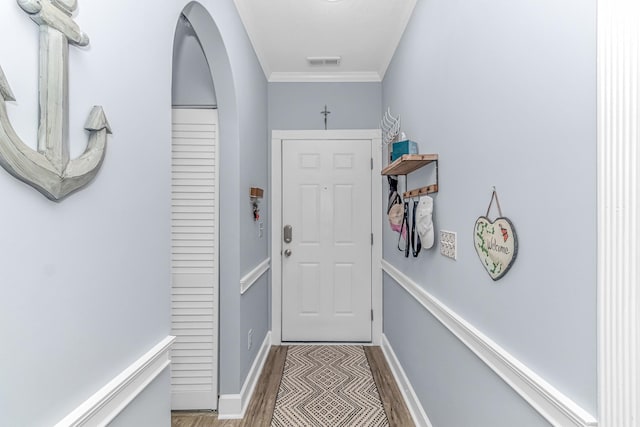 doorway with hardwood / wood-style floors and ornamental molding