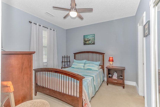 carpeted bedroom featuring a textured ceiling and ceiling fan