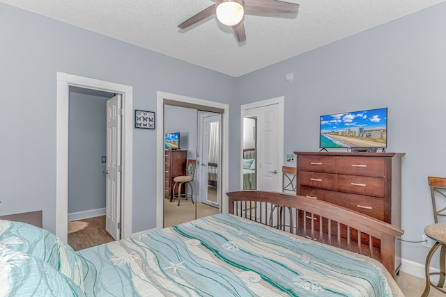 carpeted bedroom featuring connected bathroom, a textured ceiling, a closet, and ceiling fan