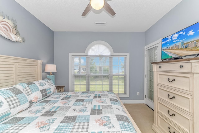 carpeted bedroom featuring multiple windows, ceiling fan, and a closet