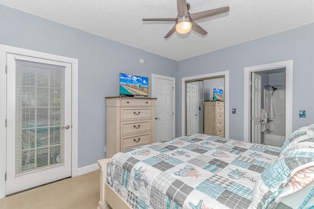 bedroom featuring light carpet, ensuite bath, a textured ceiling, and ceiling fan