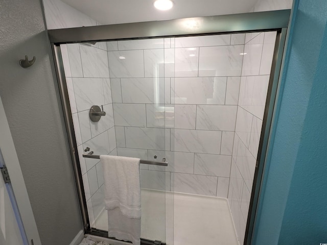 bathroom with a shower with door