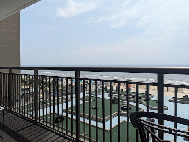 balcony with a water view and a view of the beach