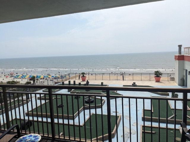 balcony with a water view and a view of the beach